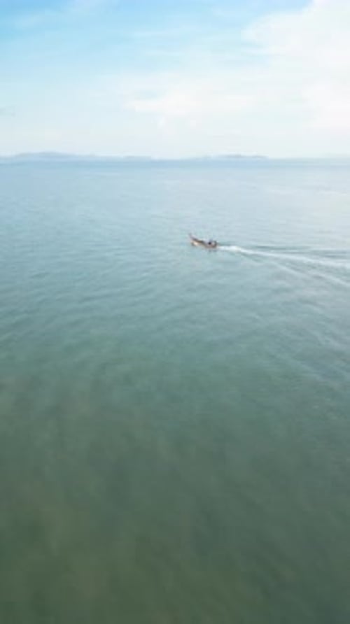 Vertical Video Drone Shot of a Sailboat Floating Near the Shoreline of a Thai Island