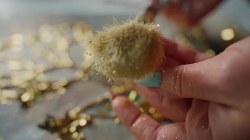 Woman Adding Gold Glitter to Resin Artwork