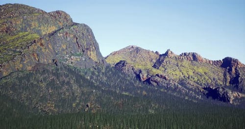 Majestic Mountain Range with Lush Forest Under Clear Blue Sky