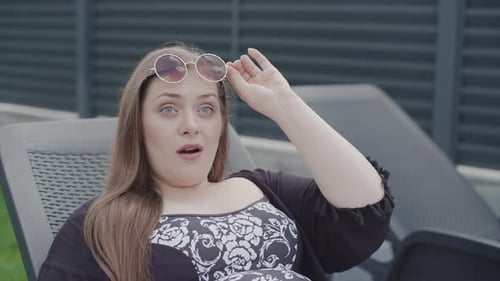 Geschäftsfrau genießt einen Moment in Zeitlupe, während sie sich im Freien in einem stilvollen Outfit entspannt