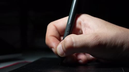 Hand Using Stylus on Drawing Tablet Close Up