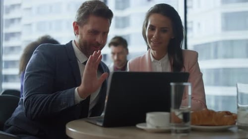 Smiling Business Partners Video Chat with Coworkers Using Laptop in Cafe. Positive