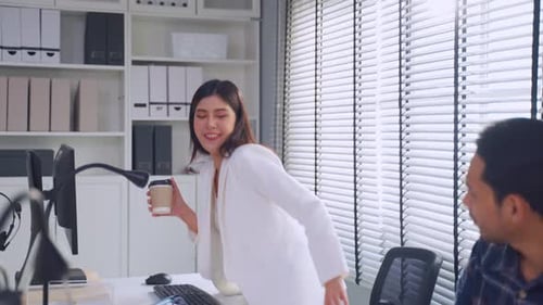 Asian attractive businessman and woman drink coffee and work in office.