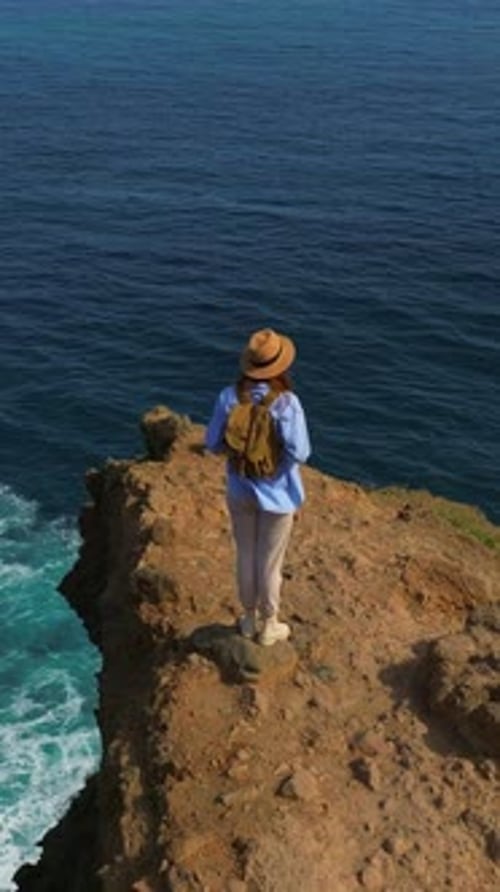 Vertical Video A Traveler Walks on a Paradise Island Active Young Woman Climbs on Top of Cliff for a