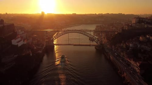 Cinematic 4k Aerial view of porto city of Portugal with famous iron bridge and city skylines at suns