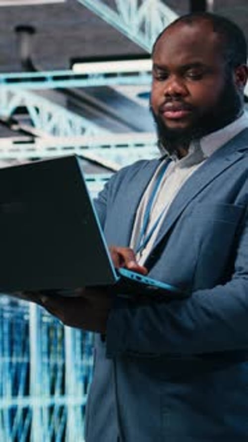 Vertical Video Happy Programmer in Server Hub Using Laptop to Do Maintenance Tasks