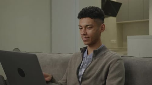 Young Adult Video Conferencing on Laptop at Home