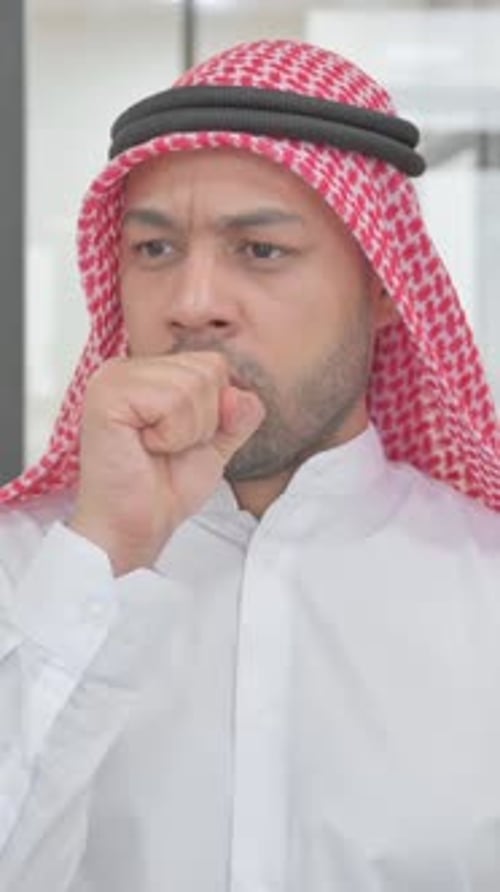 Man in Keffiyeh Coughing into Fist in Studio
