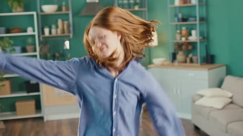Red Haired Girl Dancing and Smiling Indoors