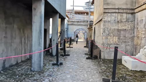 Restoration of a historical cobblestone alley with stone buildings and scaffolding