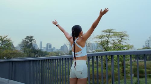 Young fitness woman in sportswear exercising in city park