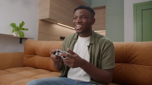 Young Adult Happily Plays Video Game at Home