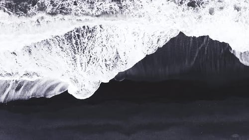 Aerial View of Iceland's Black Sand Beach with Crashing Waves