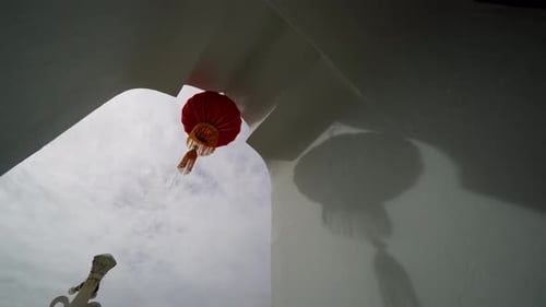 Tilt down the red lantern decoration with shadow on wall