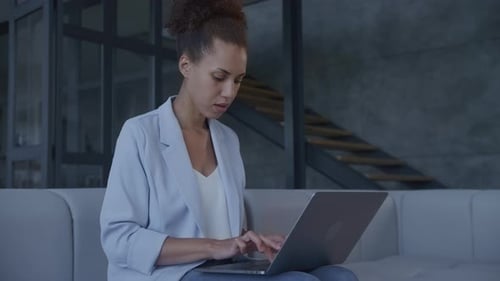 Woman Using Laptop on Couch Inside Home