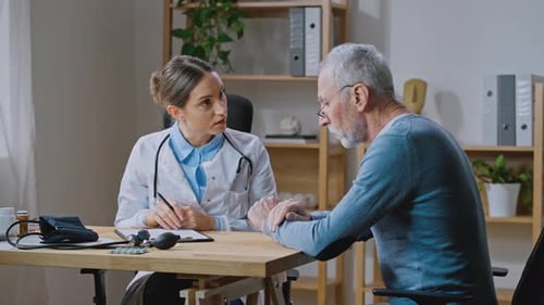 Mature Man Visiting Doctor Telling About Health Complaints