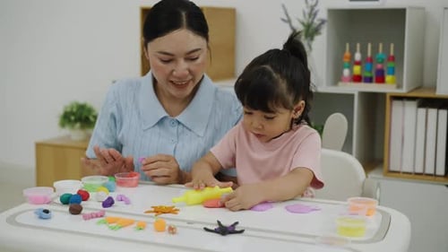Woman and Child Playing with Colorful Clay Indoors