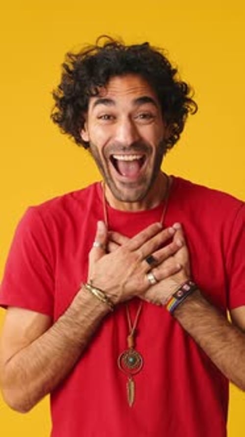 Man Expressing Joy and Surprise on Yellow Background