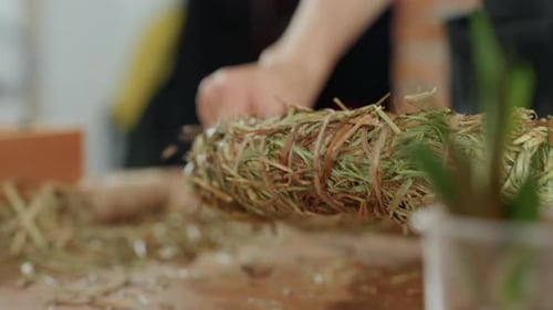 Woman's Hands Crafting a Natural Hay Wreath Indoors