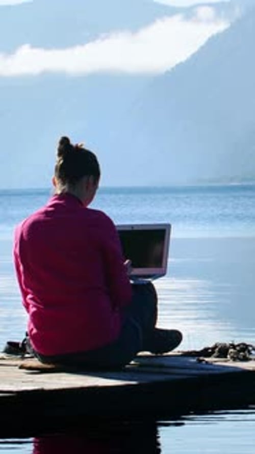 Woman Works on Laptop By Serene Lakeside in the Morning Light
