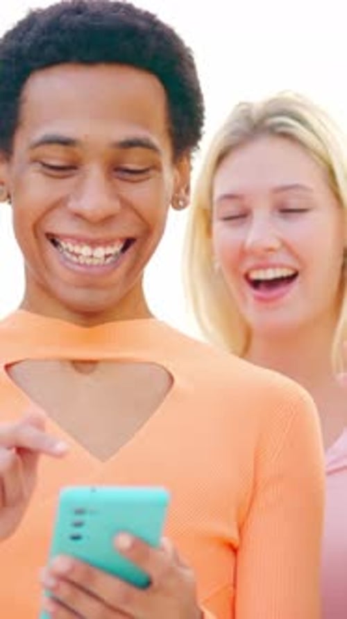 Laughing Young People Look at Phone Together