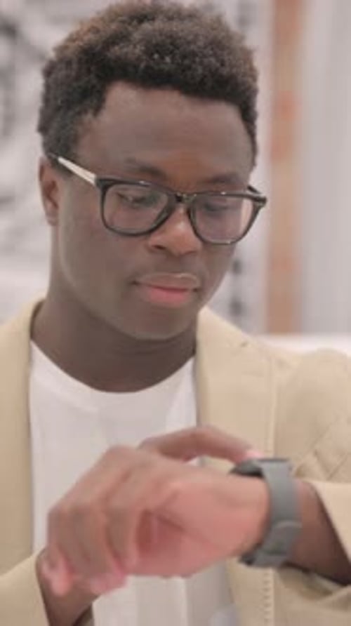 Portrait of African American Man Using Smartwatch, vertical video