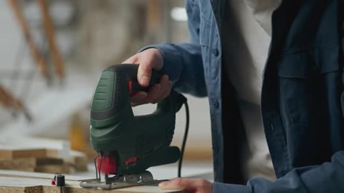 Assembling, Active Caucasian Woman Carefully Cuts Wood With A Power Tool With A Jigsaw Residential