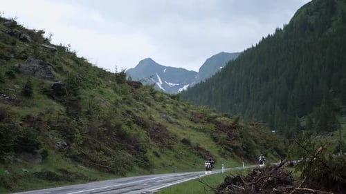 Beautiful mountain view with rain and motorcyclists on the wet road