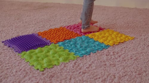 Child Walking Barefoot on Textured Sensory Mat at Home