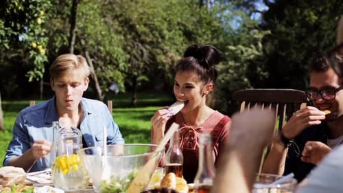 Friends Enjoying Outdoor Meal on Sunny Day