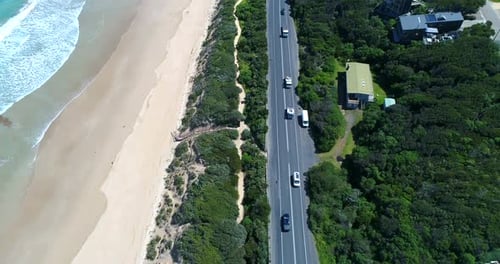 Un Drone suit une photo capturant des voitures circulant le long de l'emblématique Great Ocean Road australienne
