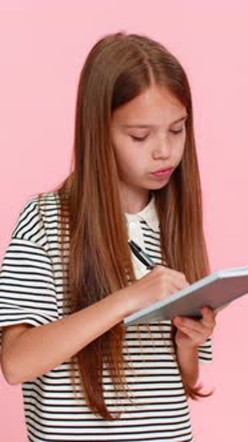 Child Girl Kid Thoughtfully Writing Notes in Notebook Diary Carefully Planning Detailed Todo List
