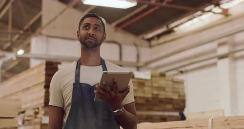 4K-Videomaterial eines jungen Mannes, der ein digitales Tablet benutzt, während er in einer Werkstatt arbeitet