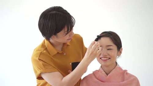 Cosmetic Artist Applying Makeup to Client