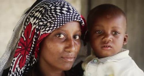 Portrait of a Beautiful African Young Mother in Traditional Clothes Looking Seriously at the