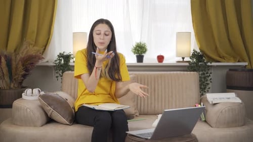 Girl Explains a Lesson on a Laptop at Home