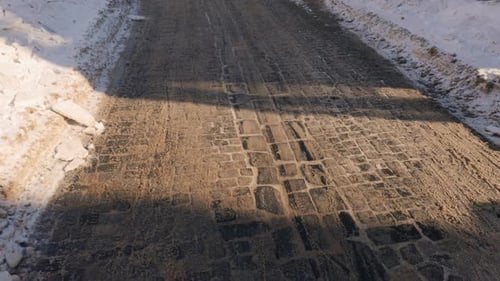 Walking on the Cobblestone Paving Covered with Dirty Snow