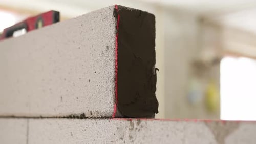Bricklayer Applies Adhesive Glue on Autoclaved Aerated Concrete Blocks with Notched Trowel Brickwork