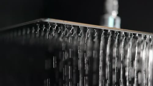 shot of a square shower from which water starts to come out in slow motion