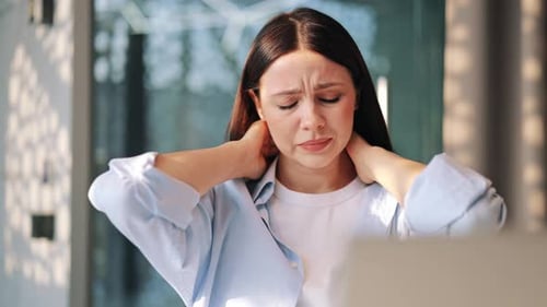 Woman Massaging Neck Due to Pain Indoors