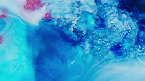 Vivid abstract of blue and red ink swirling in water, creating dynamic fluid patterns