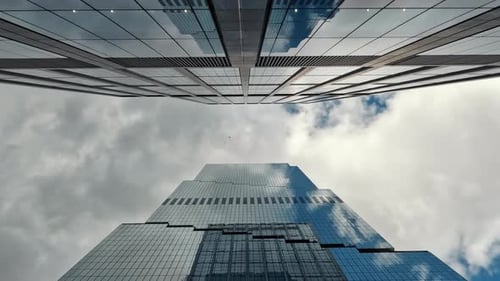 Aufwärtsansicht moderner Wolkenkratzer vor bewölktem Himmel Zeitraffer Eine eindrucksvolle Aufwärtsperspektive von
