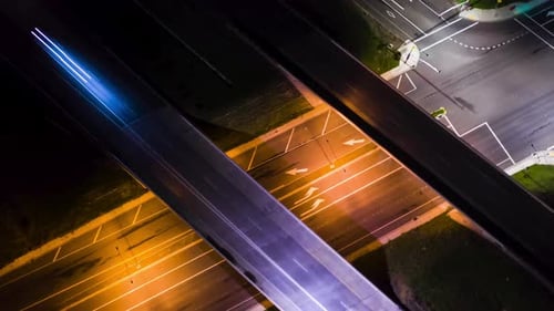 Drone hyper lapse d'intersection la nuit pendant que les voitures se dirigent vers le viaduc.