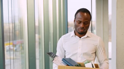 Sad Man Leaving Office with Belongings in Box