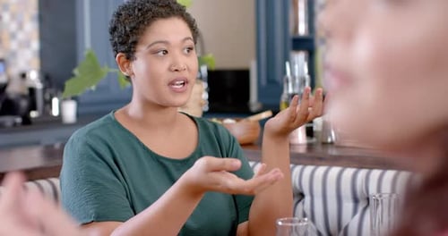 Women Talking Indoors With Hand Gestures