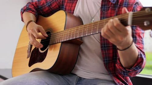 Man Strumming Acoustic Guitar Indoors