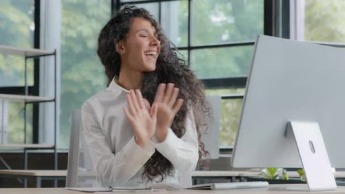 Young Happy Excited Female Office Worker Dancing at Workplace Celebrating Victory Rejoices in