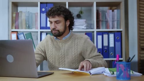 Confident Businessman Sitting at Desk Working on Laptop Thinking Typing Notes on Computer Keyboard