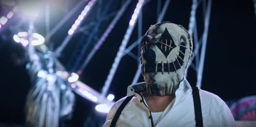 Clown Masked Person with Ferris Wheel at Night