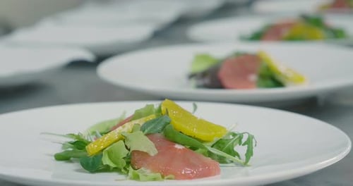 Chef Plating a Delicious Salad with Seared Salmon